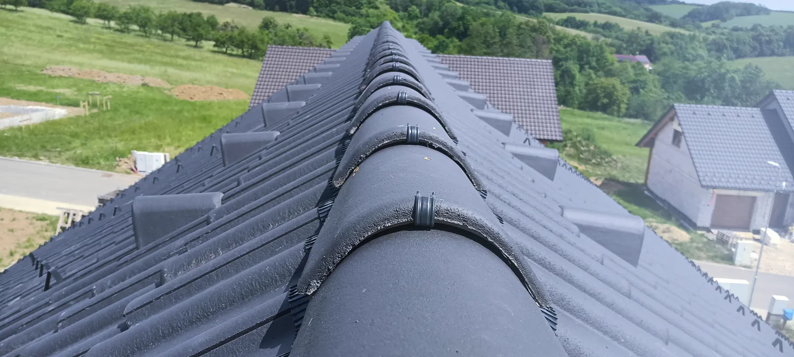 Detail hřebene střechy s tmavou taškovou krytinou